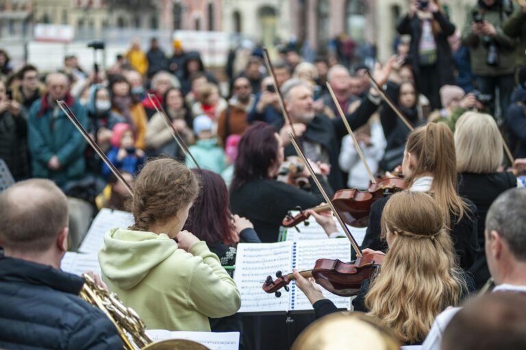 Live street orchestra performance in Lviv, Ukraine with musicians and engaged audience.